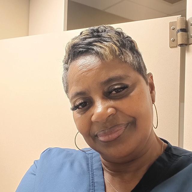 Valerie smiling in her newly designed kitchen and bath by The Savvy ID Interior Design in Henry County GA.